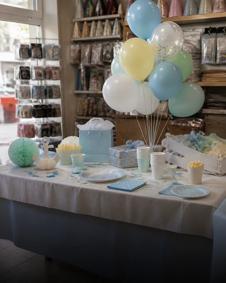 Mesa de baby shower con globos celestes, blancos y detalles suaves